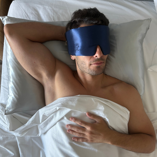 Hombre descansando con su antifaz y funda de almohada de seda