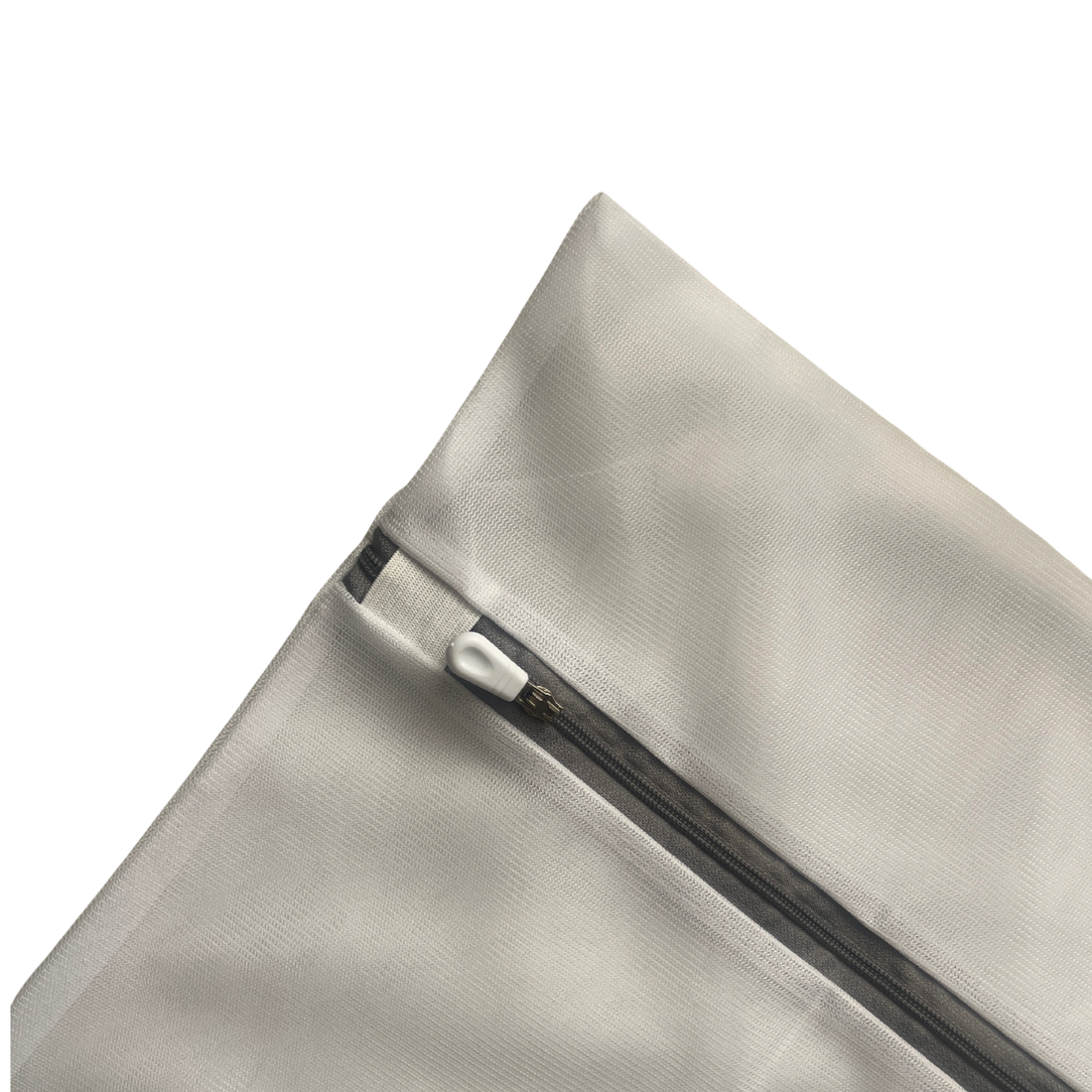 Funda de almohada de seda gris dentro de bolsa de lavado junto a detergente suave.