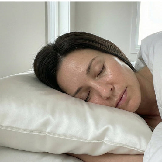 Mujer con piel radiante e hidratada durmiendo sobre una funda de almohada de seda natural Onisa Coté, ideal para prevenir el acné y proteger pieles sensibles o con rosácea